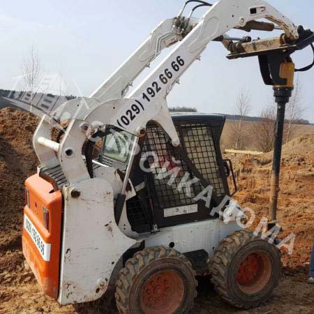 Мини-погрузчик выполняет земляные работы