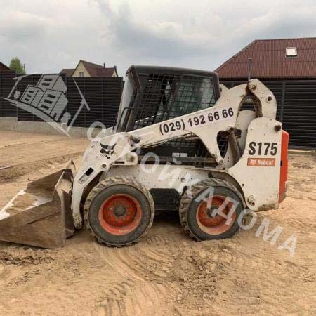 Мини-погрузчик выполняет земляные работы