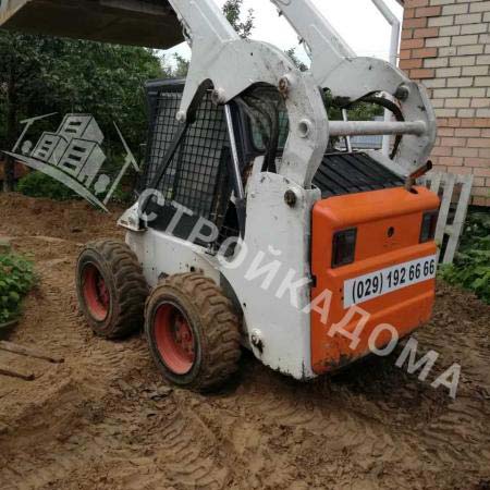 Мини-погрузчик выполняет земляные работы